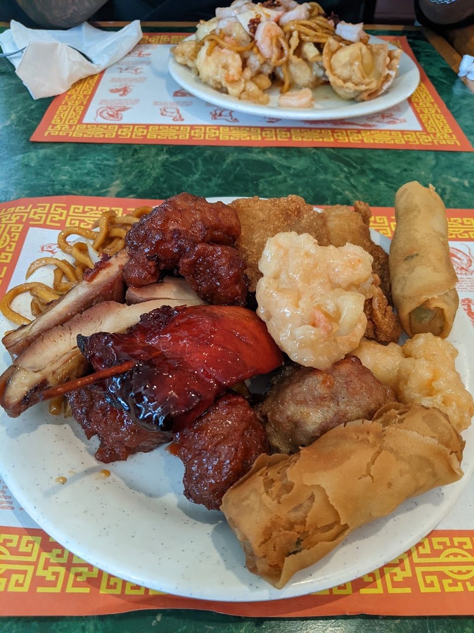 Chinese buffet dishes on a menu board