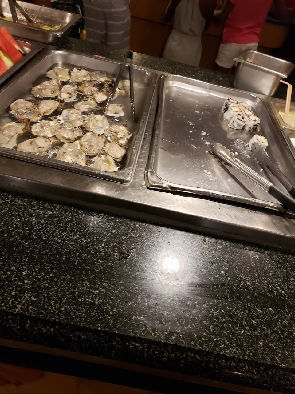 Chinese buffet dishes on a menu board
